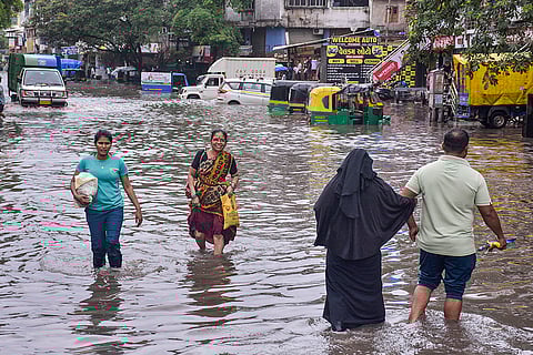 Gujarat Rains: People wade through a waterlogged road at Ved Darwaja in Surat